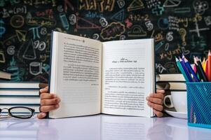 niño sentado y mostrando el libro en el aula foto