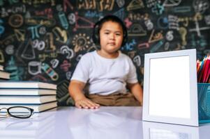 Child sitting with photo frame in the classroom