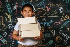 Child holding boxes in the classroom photo