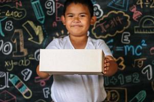 Child holding the box in the classroom photo
