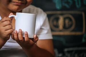 Child sitting and holding cup in the classroom photo