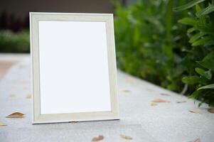 The picture frame is placed on the cement table. photo