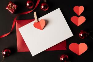 papel blanco y papel de corazón rojo pegado sobre un fondo negro. foto