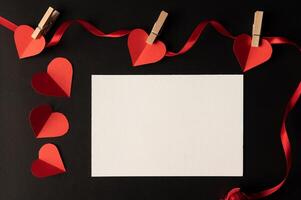 White paper and red heart paper pasted on a black background. photo