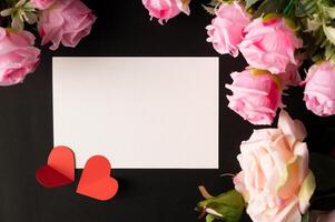 White paper and red heart paper pasted on a black background. photo