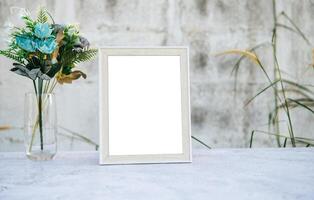 The picture frame is placed on the cement table. photo