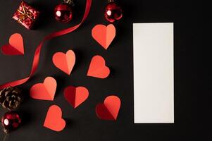 White paper and red heart paper pasted on a black background. photo