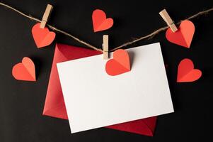 White paper and red heart paper pasted on a black background. photo