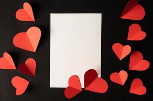 White paper and red heart paper pasted on a black background. photo