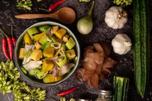 Kaeng Liang in a bowl with spices on a black cement floor. photo