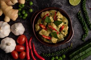 Pork green curry in a brown bowl with spices photo