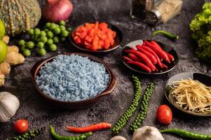 Butterfly Pea flower rice in a brown cup with spices on black cement. photo