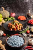 Butterfly Pea flower rice in a brown cup with spices on black cement. photo