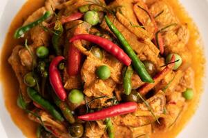 Red curry with pork in a white plate photo