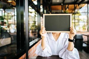 mujer, tenencia, pizarra negra, en, café foto