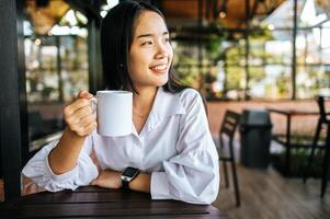 taza blanca en la mano en tiempo de relajación foto