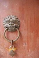 Ancient traditional red wooden door and metal lion door ring photo