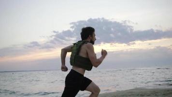 Entrenamiento joven atleta barbudo al aire libre con chaleco lastrado video