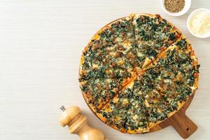 Spinach and cheese pizza on wood tray photo