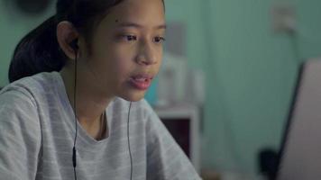 jovencita hablando con sus amigos a través de una videollamada en una computadora portátil en casa. video