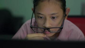 Girl wearing loose eyeglasses on her face playing online games video