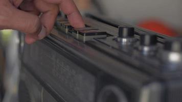 Man's finger presses a button to play old cassette tape player. video