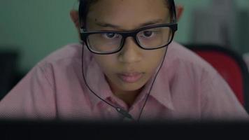 Serious schoolgirl using computer on home internet surfing website. video