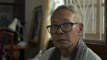 lustiger Großvater, der seine Augenbraue hochhebt und zu Hause ein Videoporträt posiert. video