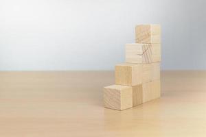 Hand arranging wood block stacking as step stair on wooden table photo