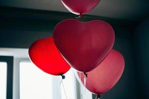 vintage red heart shaped balloons against window
