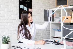 Young latin woman in white shirt teaching english online photo