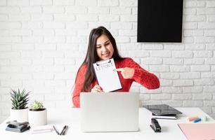 Young latin woman in red sweater teaching english online photo