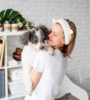 Mujer vistiendo albornoces haciendo procedimientos de spa con su perro foto