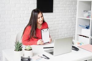 Young latin woman in red sweater teaching english online photo