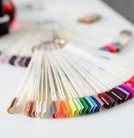 Puntas de uñas de plástico de colores sobre la mesa en el salón de manicura foto