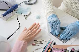 Manicure master in mask and gloves doing stamping to the client photo
