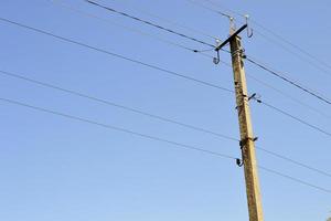 Poste eléctrico de potencia con cable de línea sobre fondo de color cerrar foto