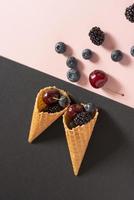 blueberries, cherries and blackberries in two waffle cones photo