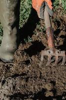 El agricultor prepara la tierra para plantar con una herramienta de arado en primavera. foto