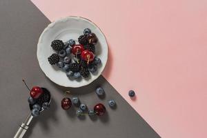 blueberries, blackberries, cherries on plate and ice cream spoon photo