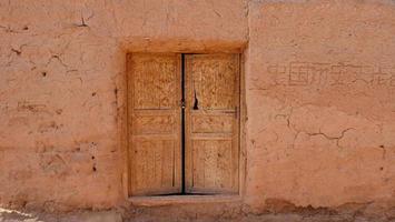 old house wall wooden door in Tuyoq village valley Xinjiang China. photo