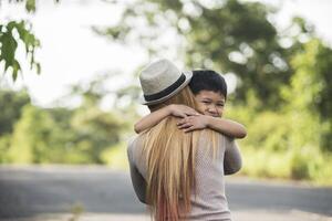 Portrait of mother and son happy cuddle together in the park. photo