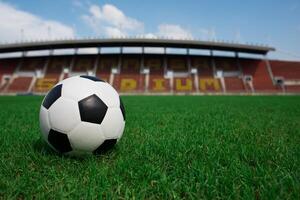 Balón de fútbol sobre césped con fondo de estadio foto