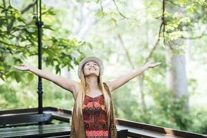 Happy young woman raising her hands in the morning at cafe photo