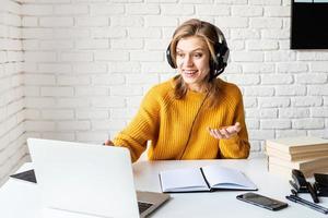 mujer joven, en, negro, auriculares, estudiar, en línea, usar la computadora portátil foto