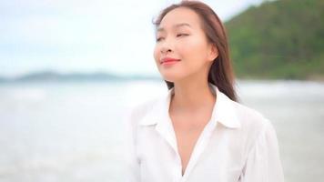 mujer asiática disfruta de un día en la playa