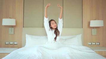 Mulher asiática relaxando na cama no interior do quarto