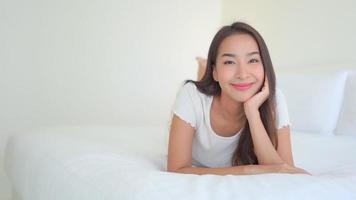 Asian woman relax on bed in bedroom interior video