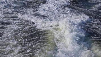 vagues de pulvérisation de mousse faites par un navire flottant dans l'océan