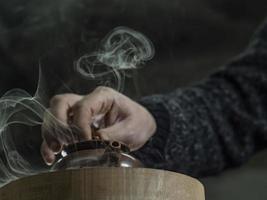 close-up male hand closed the lid of a clay teapot made of yixing clay photo